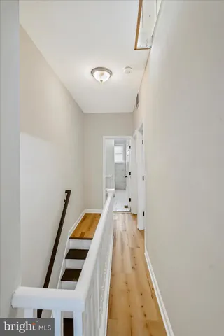 a room with wooden floor and stainless steel appliances