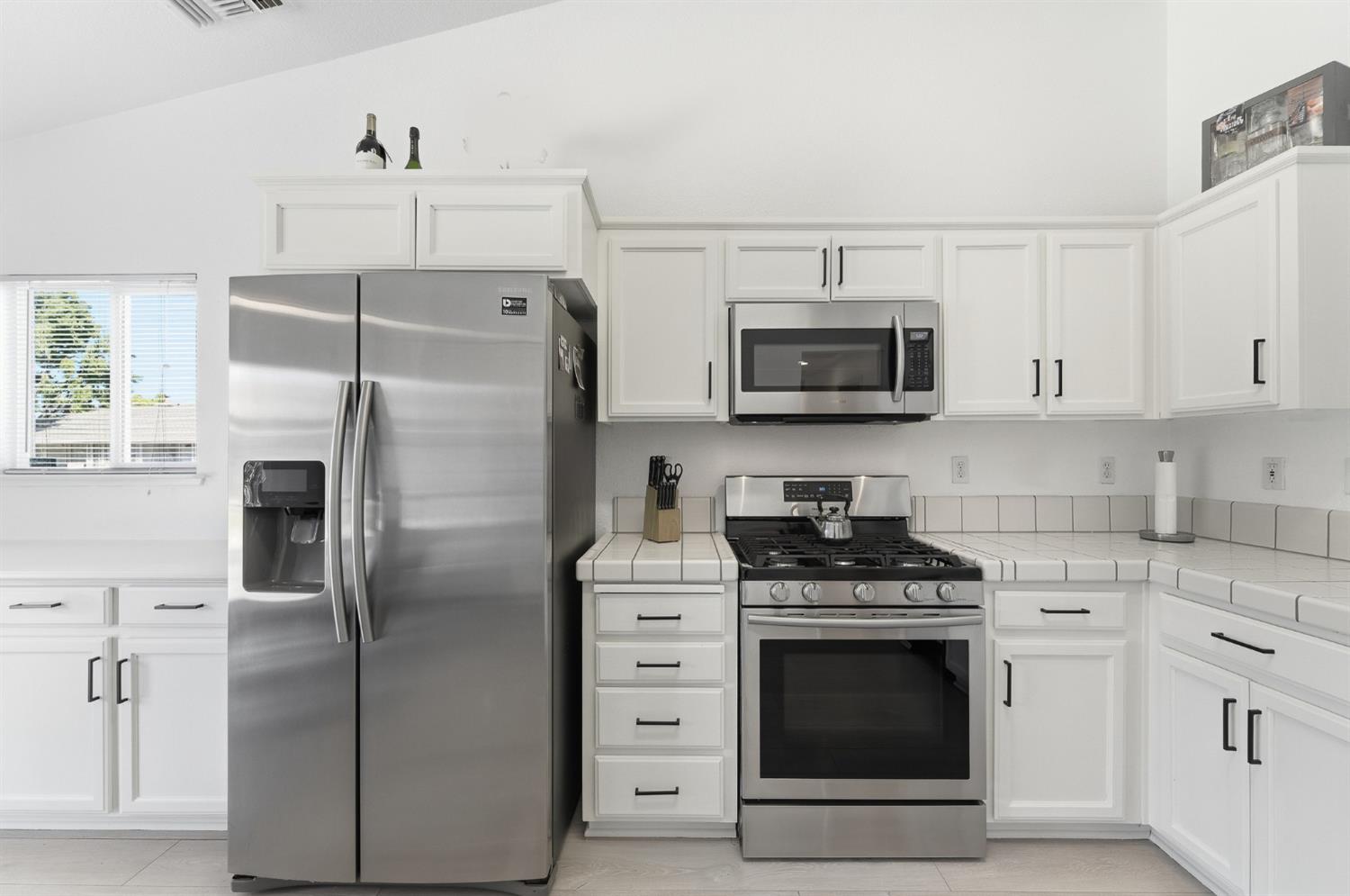 1933 Lifetime Drive Modesto, CA 95355 - Photo 13 of 38 a kitchen with stainless steel appliances granite countertop a refrigerator stove and white cabinets