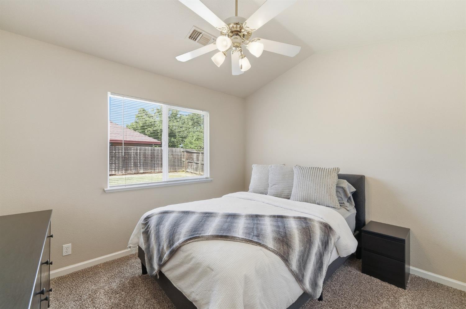 1933 Lifetime Drive Modesto, CA 95355 - Photo 25 of 38 a bedroom with a bed and a chandelier