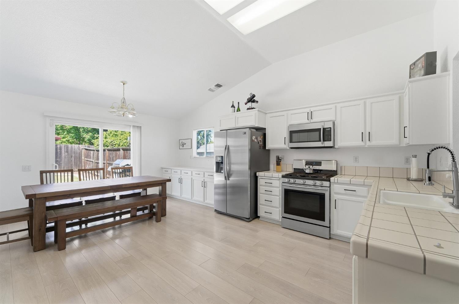 1933 Lifetime Drive Modesto, CA 95355 - Photo 10 of 38 a kitchen with stainless steel appliances a stove a sink cabinets and a window