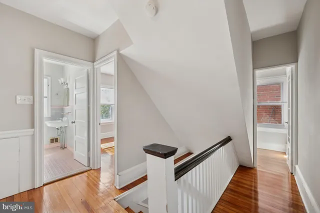 a view of a hallway with wooden floor and staircase