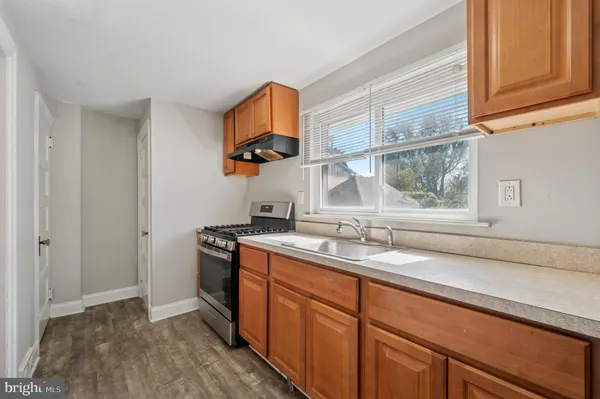 a kitchen with stainless steel appliances granite countertop a sink and a stove next to a window