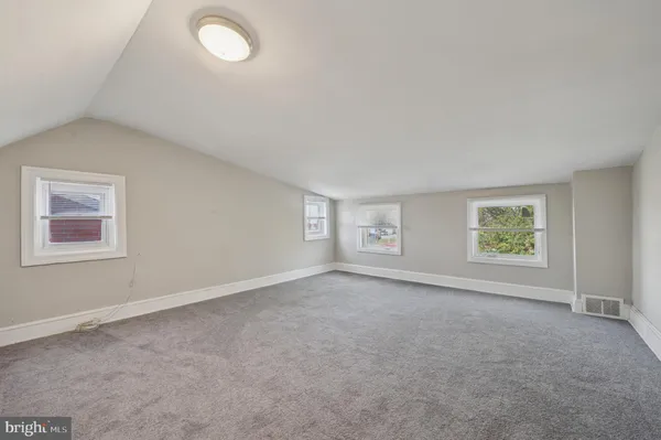 an empty room with windows and closet