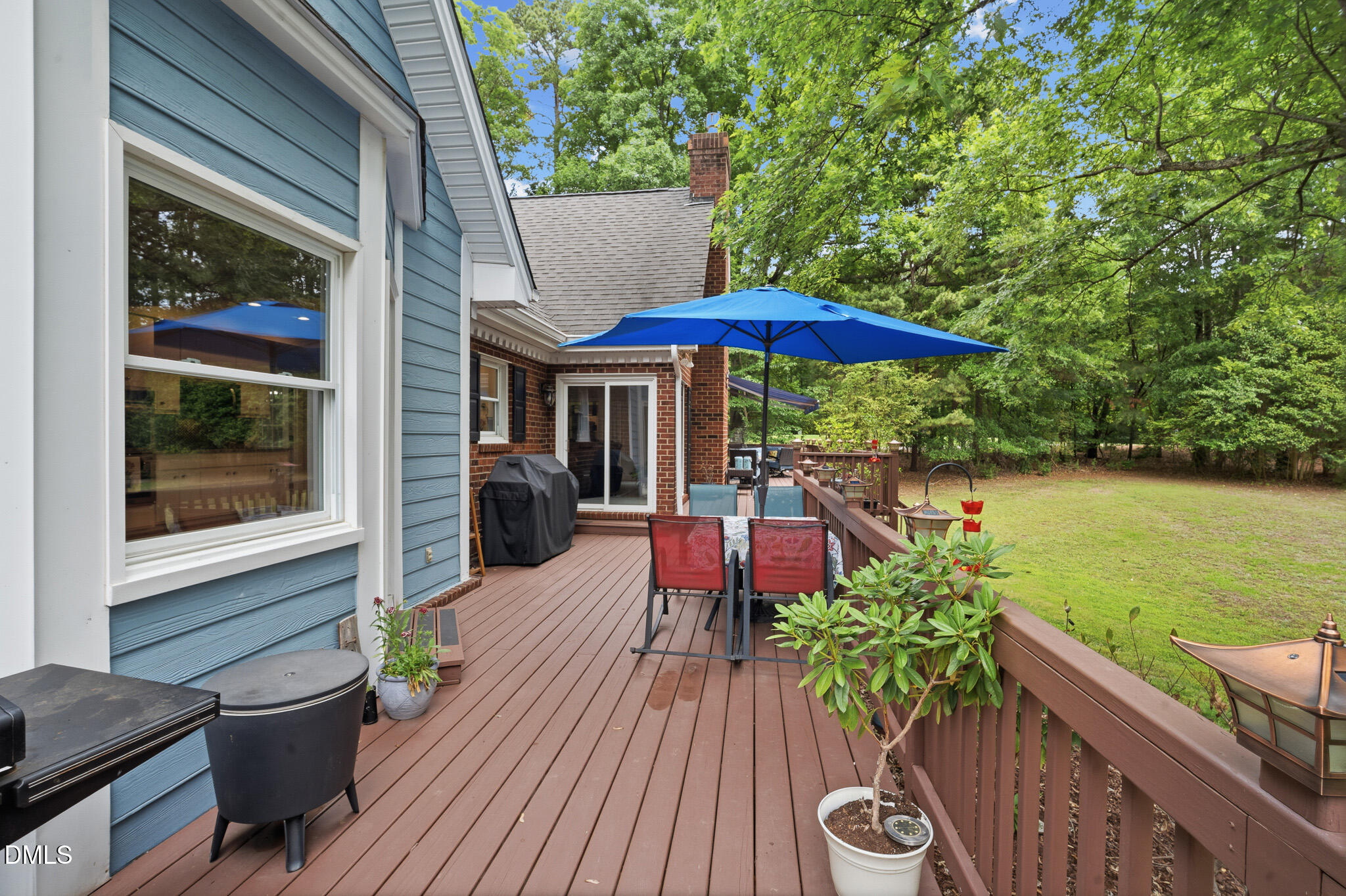 3735 Stoneybrook Drive Durham, NC 27705 - Photo 34 of 44 a view of a patio with couches table and chairs under an umbrella with wooden floor