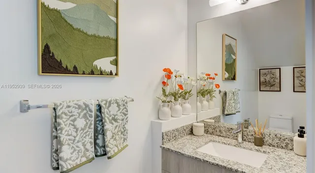 a bathroom with a granite countertop sink and a mirror