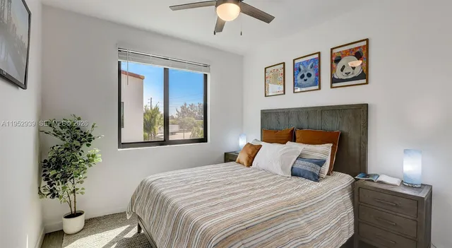 a bedroom with a large bed and a potted plant
