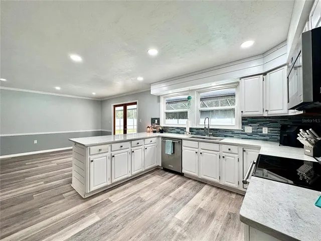 a kitchen with granite countertop cabinets stainless steel appliances a sink and a window