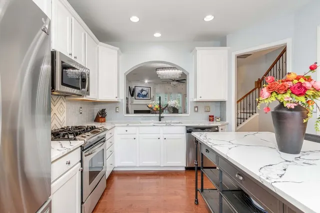 a kitchen with stainless steel appliances granite countertop a stove refrigerator sink and cabinets