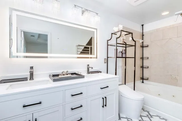 a bathroom with a sink a toilet and shower