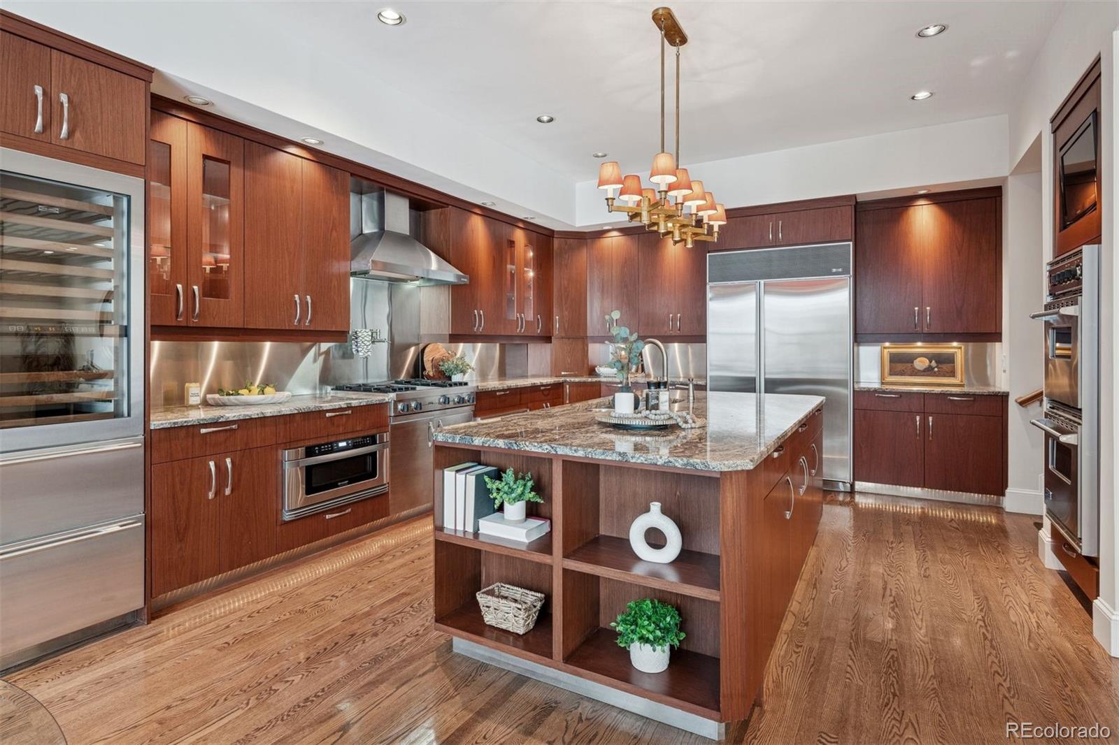 375 Clayton Street Denver, CO 80206 - Photo 9 of 45 a kitchen with kitchen island granite countertop a stove a counter top space and cabinets