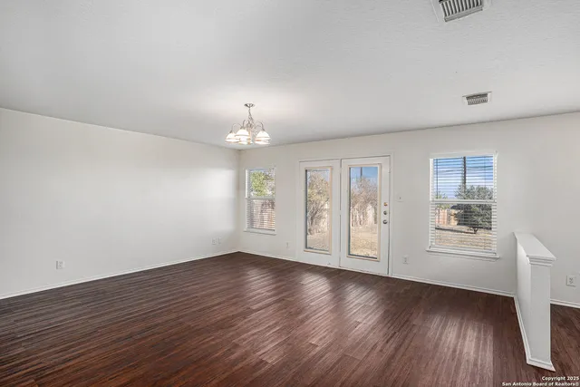 an empty room with wooden floor and window