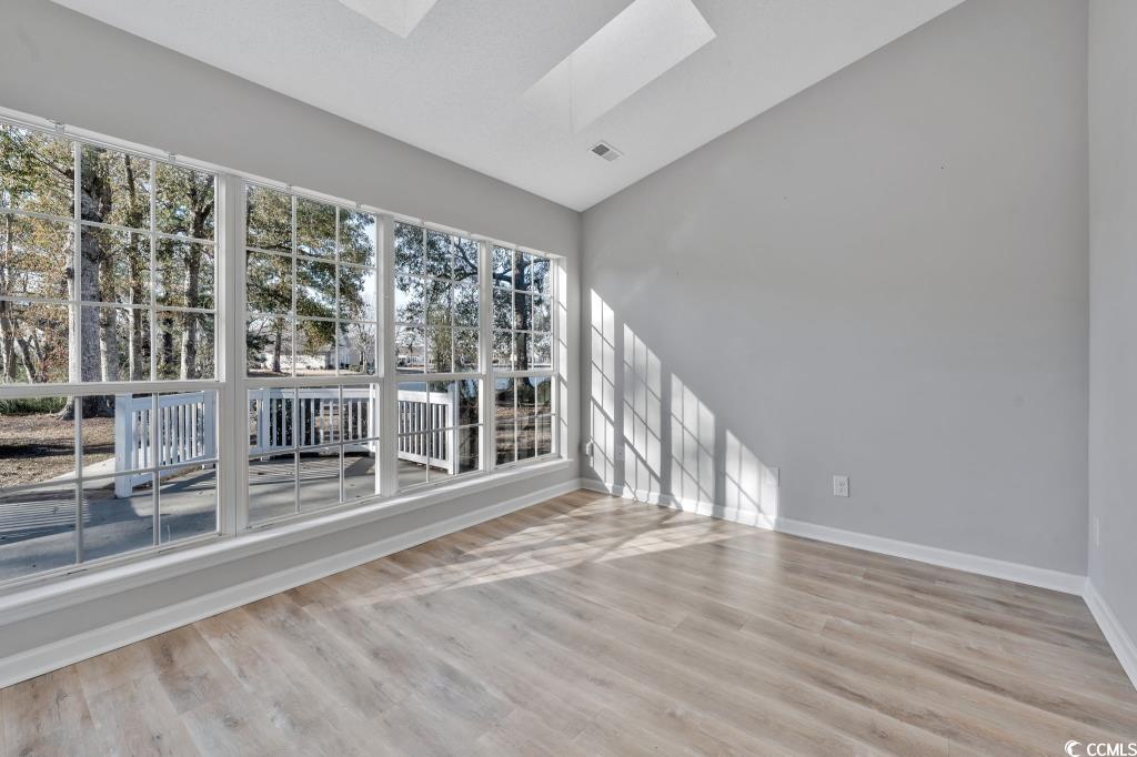 1639 Coventry Road Surfside Beach, SC 29575 - Photo 28 of 38 Unfurnished room featuring vaulted ceiling with skylight, hardwood / wood-style floors, and a wealth of natural light