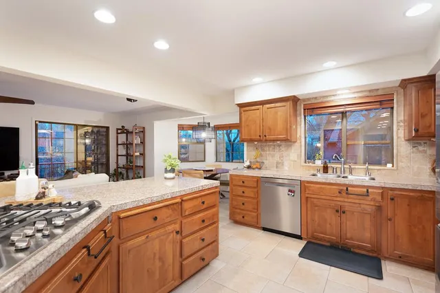 a kitchen with stainless steel appliances granite countertop a sink a stove and cabinets