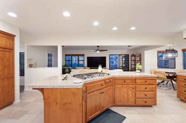 a living room with furniture kitchen view and a large window