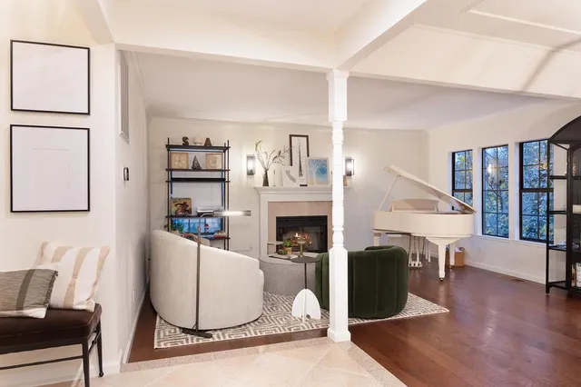 a living room with furniture a fireplace and a large window