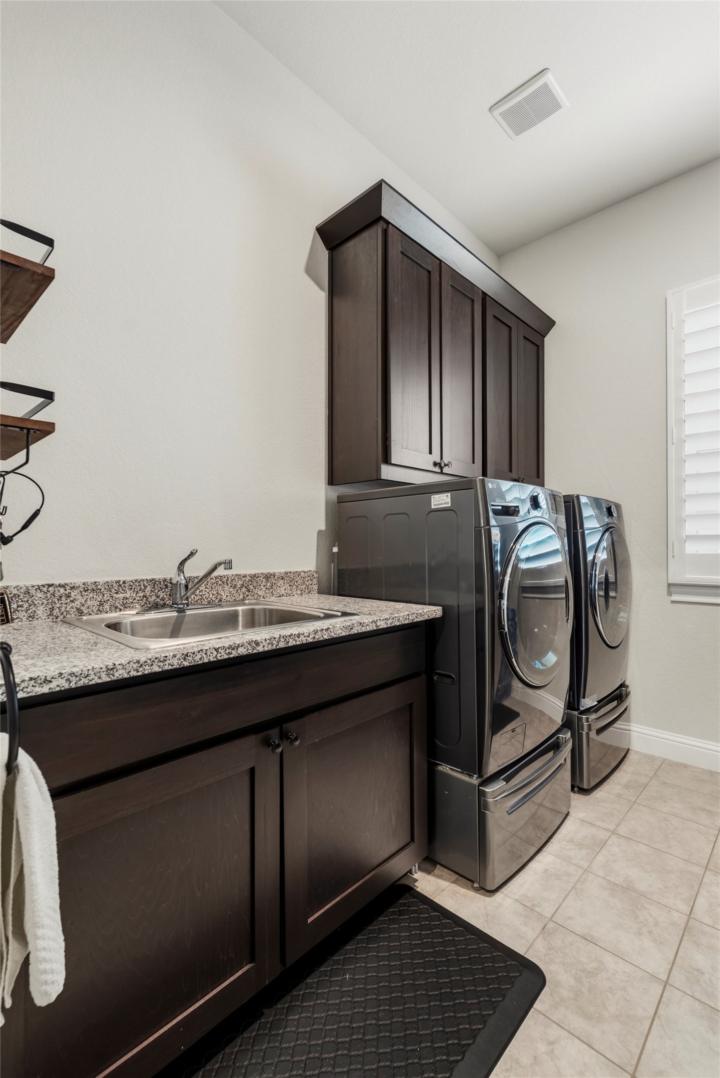 4513 Vieste View Leander, TX 78641 - Photo 38 of 40 Laundry area featuring a utility sink with a dual basin, granite-style countertop, and dark wood-finish cabinetry