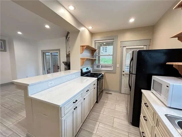 a large kitchen with a stove a refrigerator and a sink