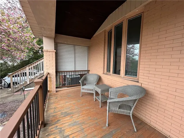 a balcony with wooden floor table and chairs