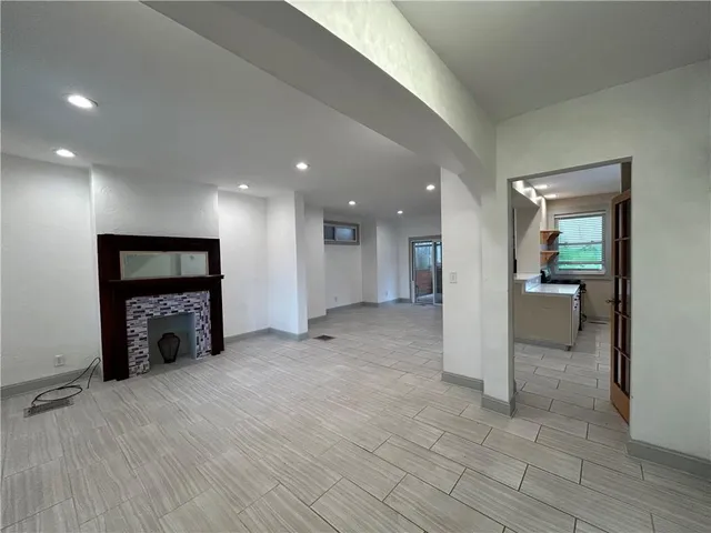 an empty room with windows and a fireplace