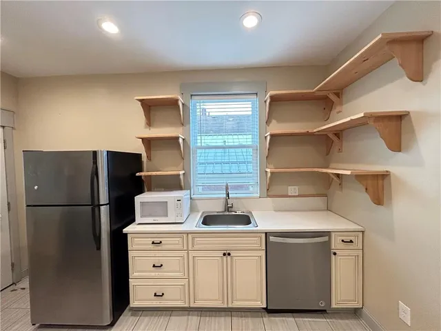 a kitchen with white cabinets and refrigerator