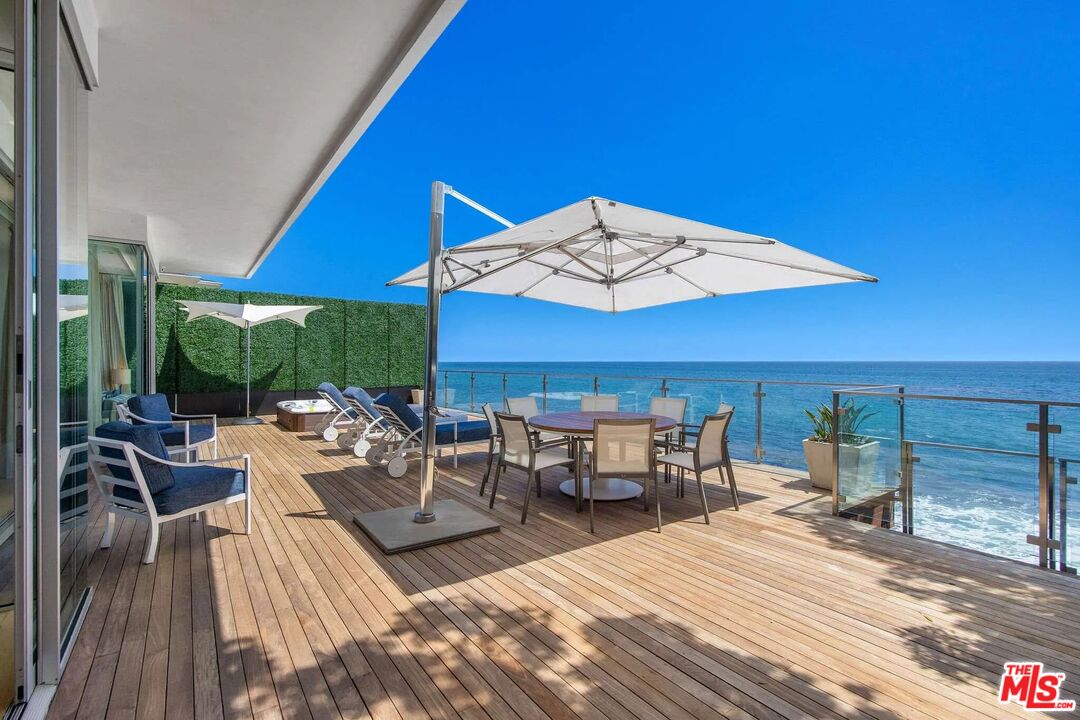24380 Malibu Road Malibu, CA 90265 - Photo 17 of 48 a view of a patio with lawn chairs under an umbrella