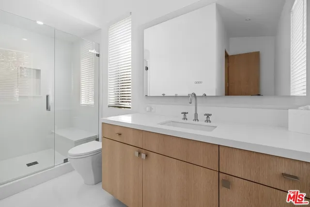 a bathroom with a double vanity sink toilet and shower