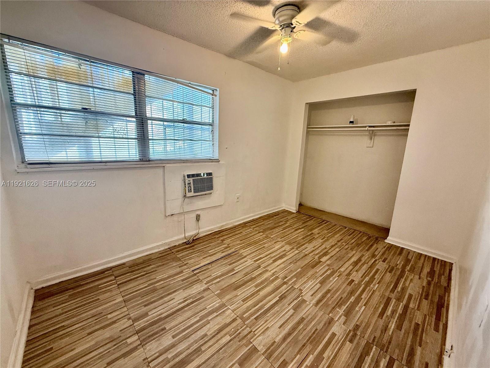 724 Southwest 11th Avenue, Unit 1 Miami, FL 33130 - Photo 5 of 7 an empty room with wooden floor closet and windows