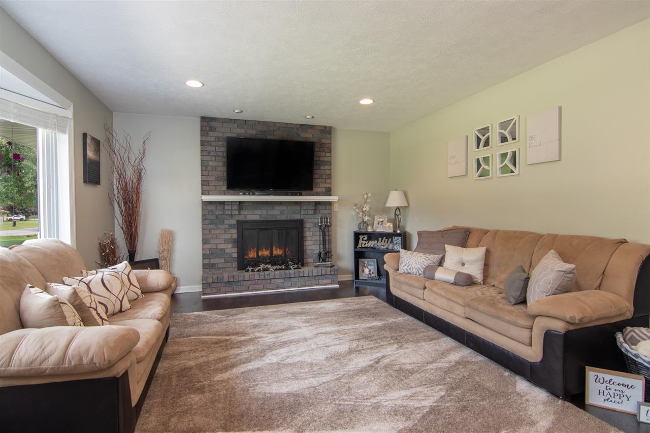 5780 Rural Edge Drive Roscoe, IL 61073 - Photo 5 of 25 a living room with furniture a flat screen tv and a fireplace