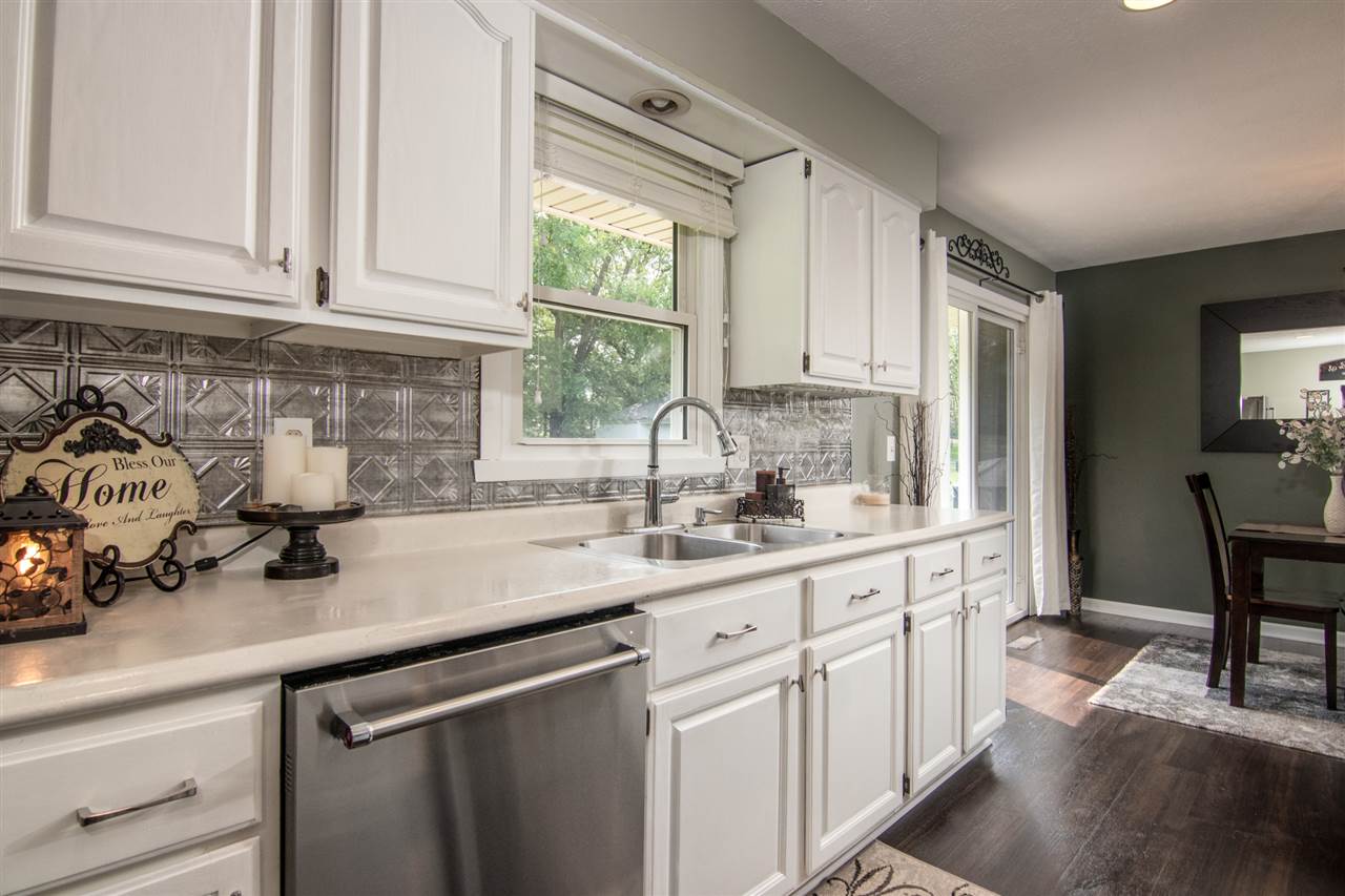 5780 Rural Edge Drive Roscoe, IL 61073 - Photo 9 of 25 a kitchen with stainless steel appliances granite countertop a sink a stove and white cabinets
