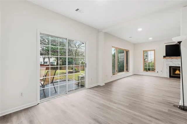 a view of an empty room with a fireplace and a window