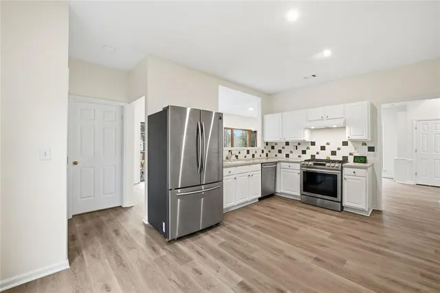 a kitchen with wooden floors and white appliances