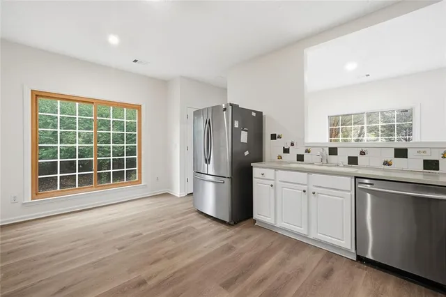 a kitchen with stainless steel appliances a refrigerator sink and cabinets