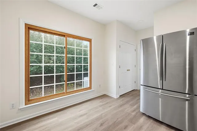 a view of empty room with wooden floor and window