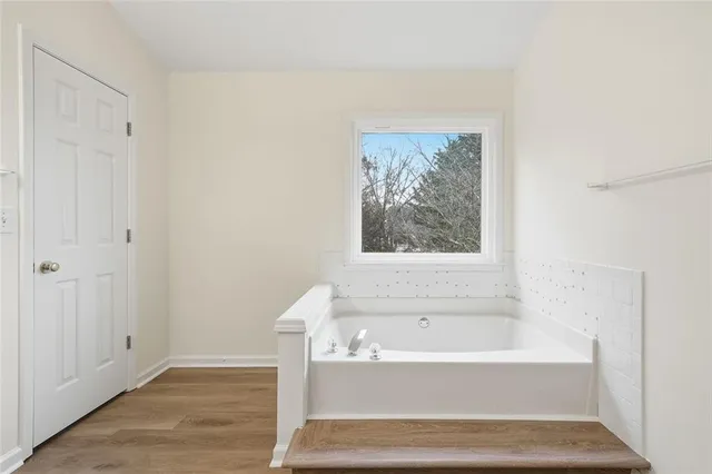 a bathroom with bathtub and window