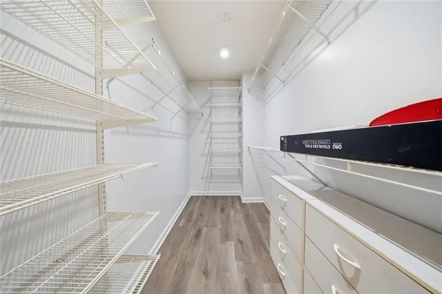 a view of walk in closet with wooden floor