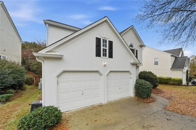 a view of a white house next to a yard