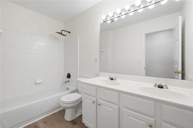 a bathroom with a toilet a sink a mirror and a bathtub