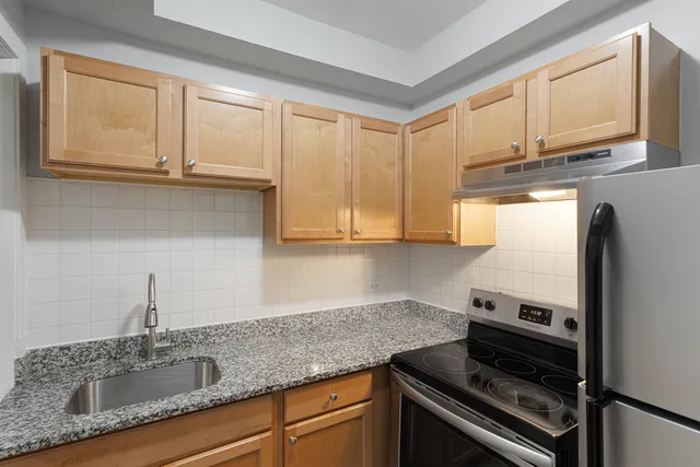 a kitchen with granite countertop cabinets stainless steel appliances and a sink