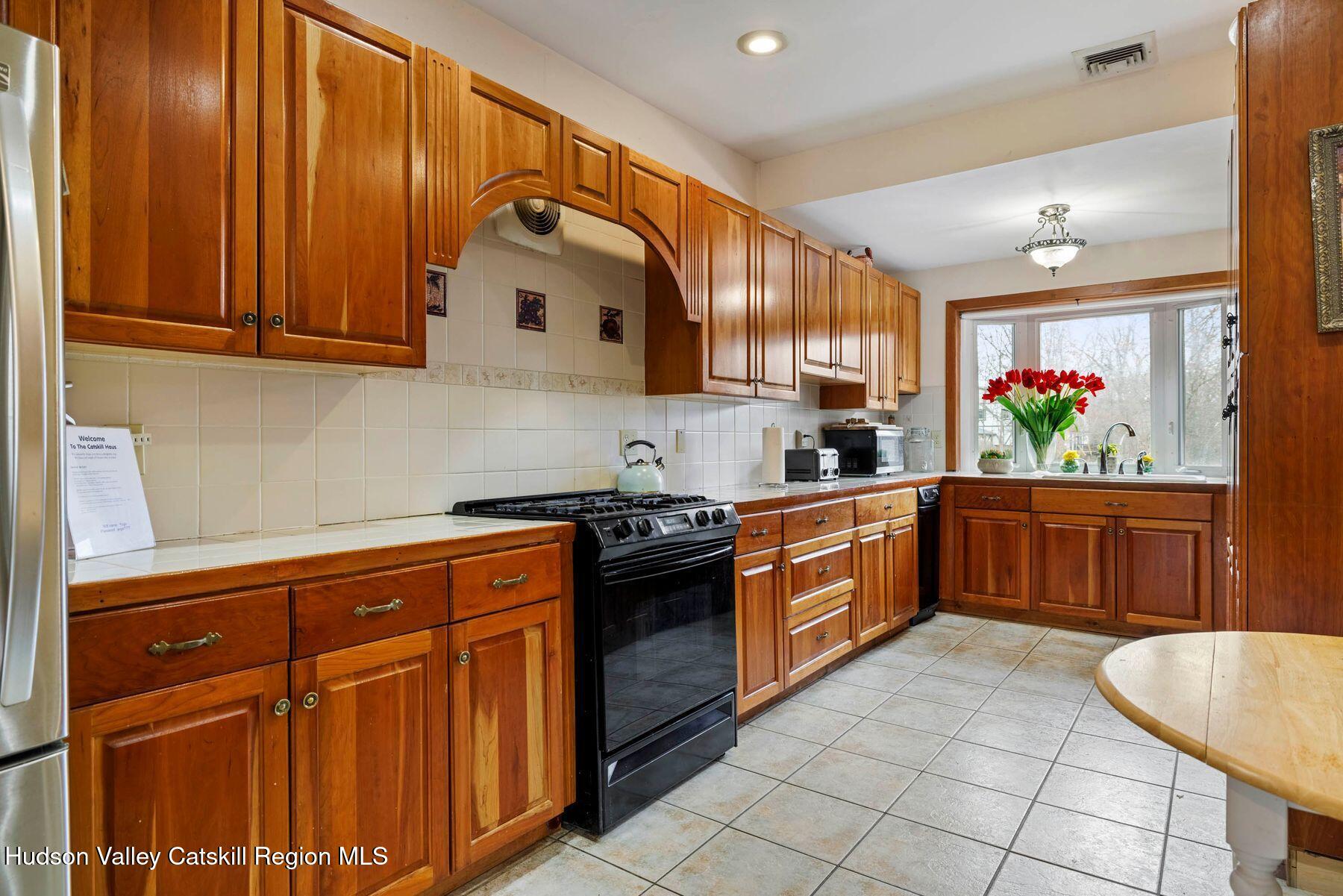 404 Winter Clove Road Round Top, NY 12473 - Photo 14 of 133 a kitchen with stainless steel appliances granite countertop a stove a sink and a microwave