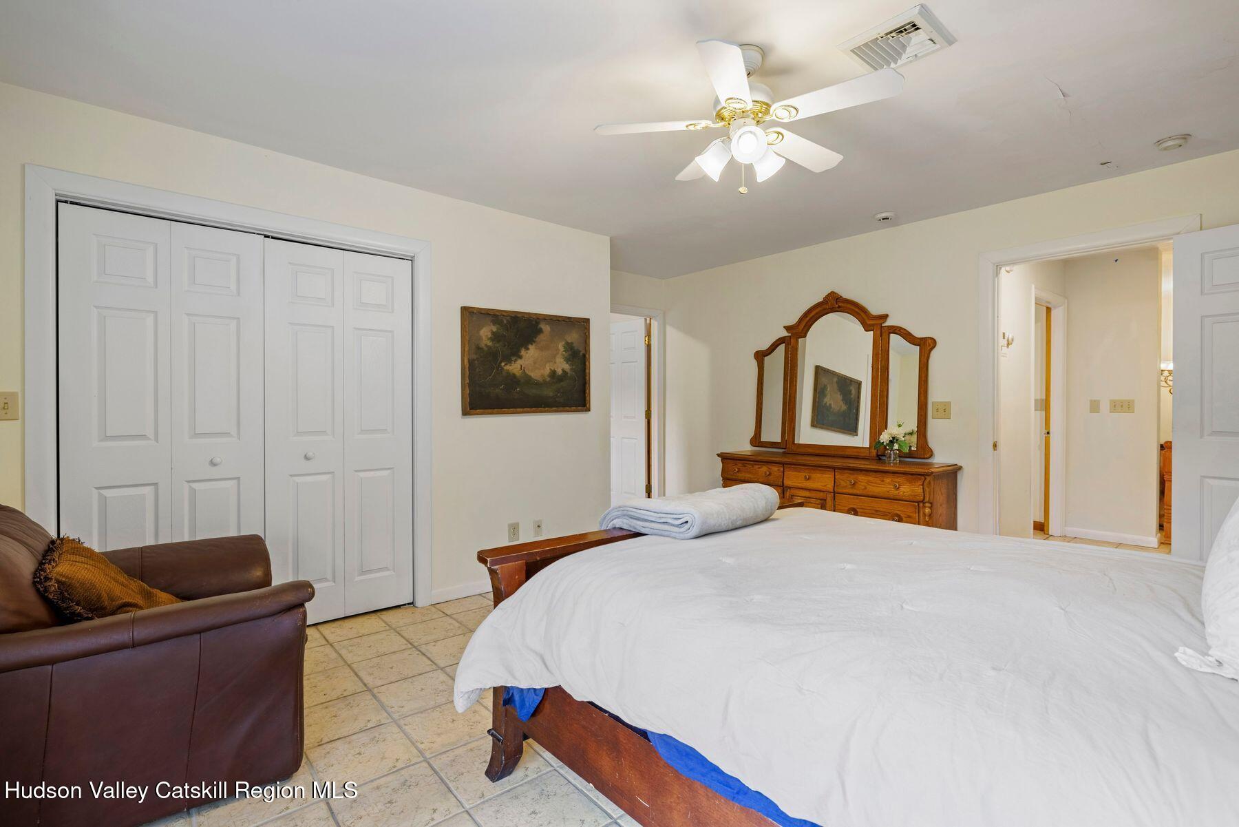 404 Winter Clove Road Round Top, NY 12473 - Photo 33 of 133 a bedroom with a bed and a chandelier