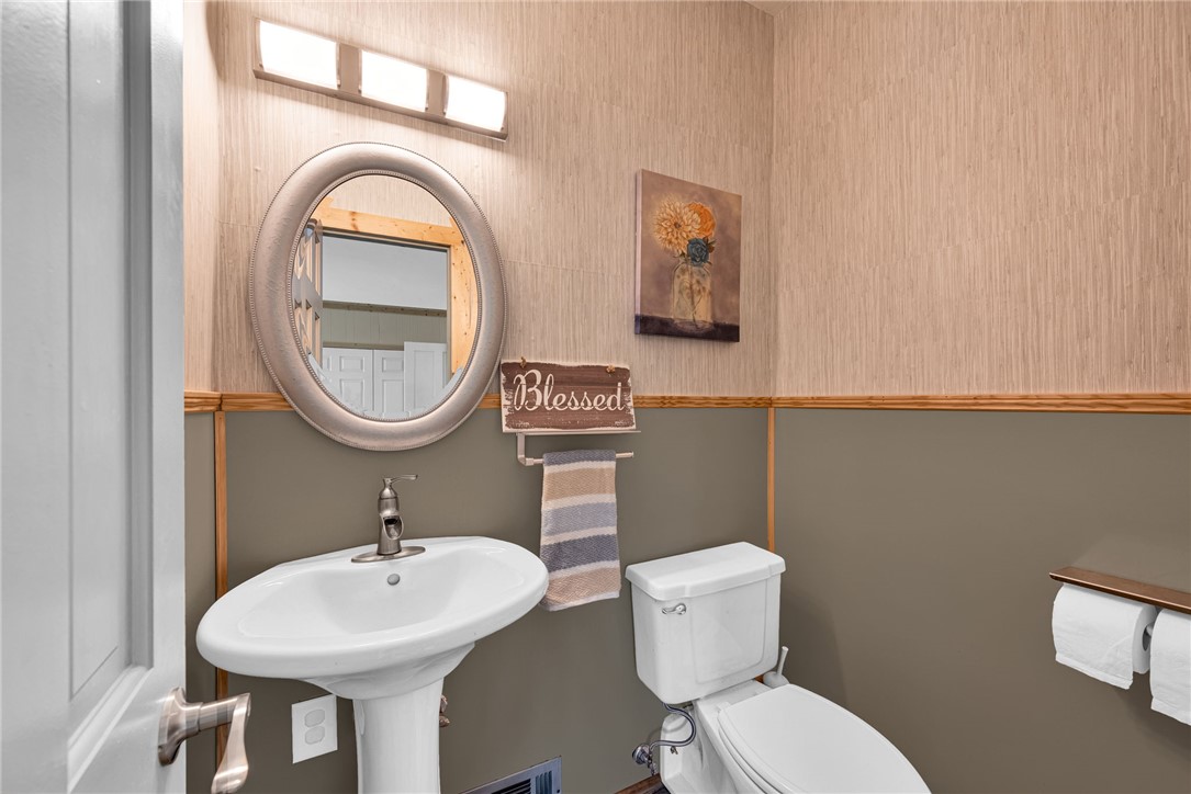 433 Latham Road Easley, SC 29640 - Photo 30 of 50 A compact and functional bathroom features a classic pedestal sink and toilet, perfect for guest use.