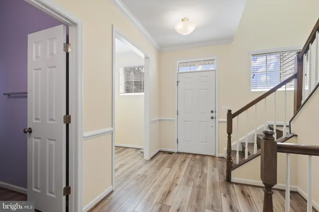 a view of a hallway with wooden floor and stairs