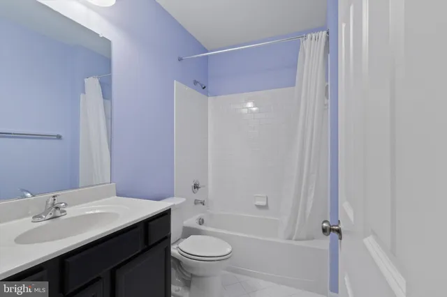 a bathroom with a bathtub shower sink mirror vanity and toilet