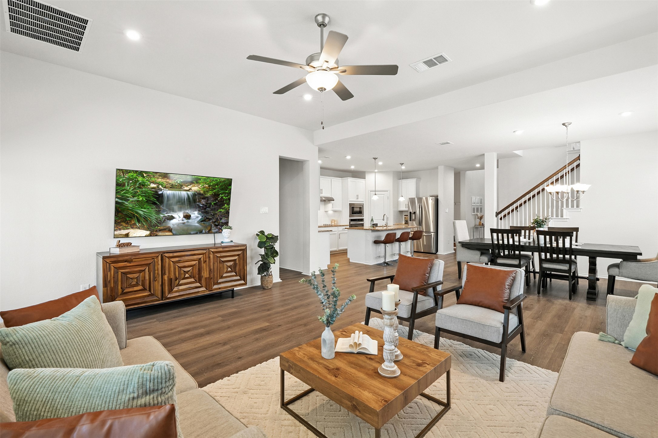 Living area featuring light wood-style floors, recessed lighting, a ceiling fan, and stairs