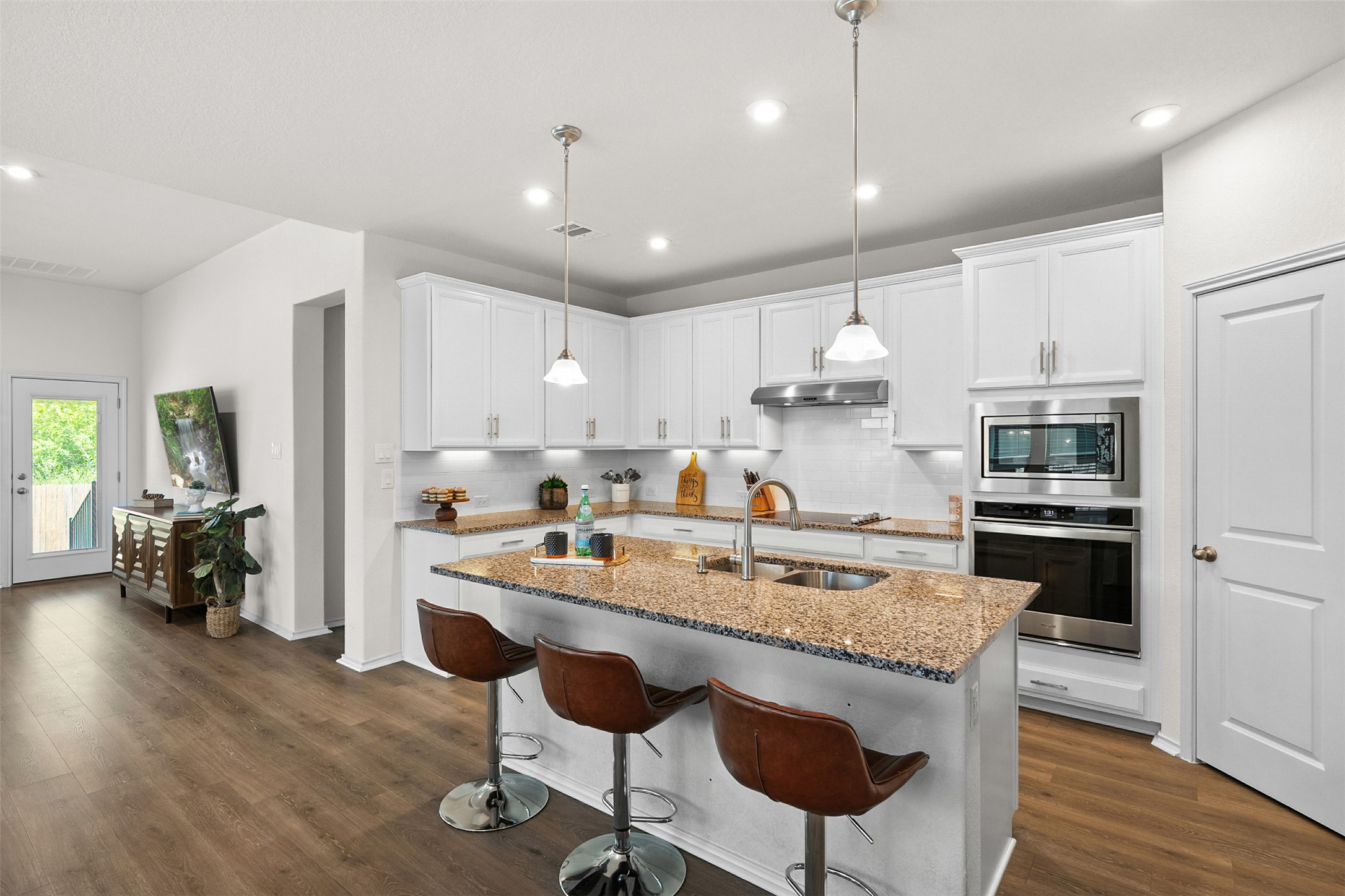 211 Brookside Street Hutto, TX 78634 - Photo 12 of 40 Kitchen featuring tasteful backsplash, stainless steel appliances, light stone counters, a kitchen bar, and recessed lighting