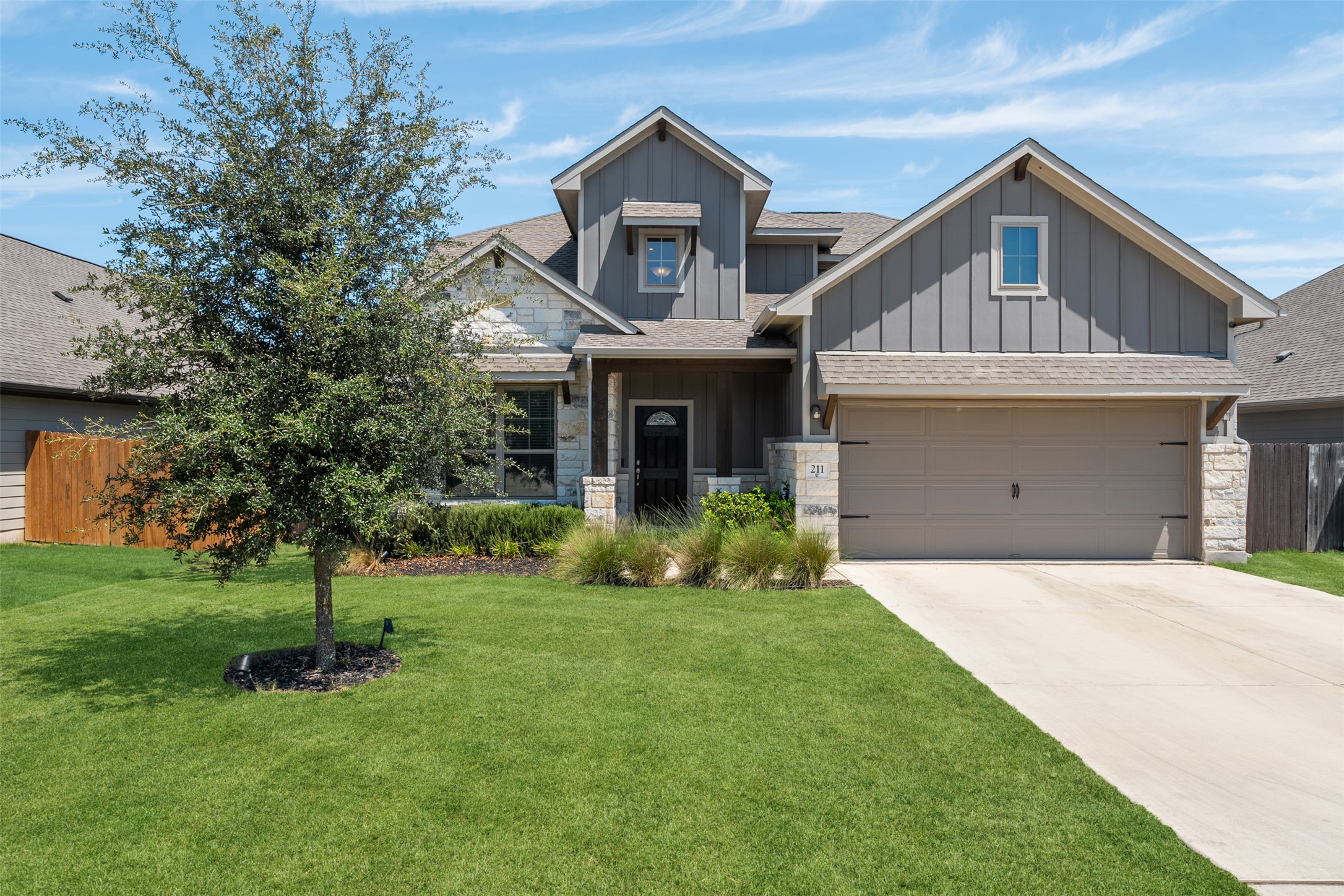 211 Brookside Street Hutto, TX 78634 - Photo 2 of 40 Craftsman inspired home featuring board and batten siding, stone siding, a garage, and concrete driveway