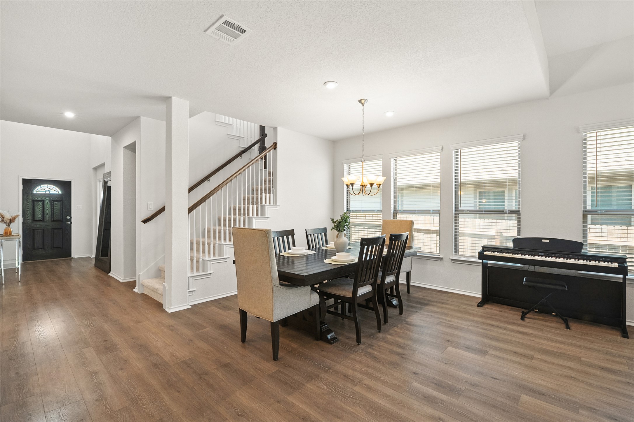 211 Brookside Street Hutto, TX 78634 - Photo 22 of 40 Dining space featuring stairs, a chandelier, and wood finished floors