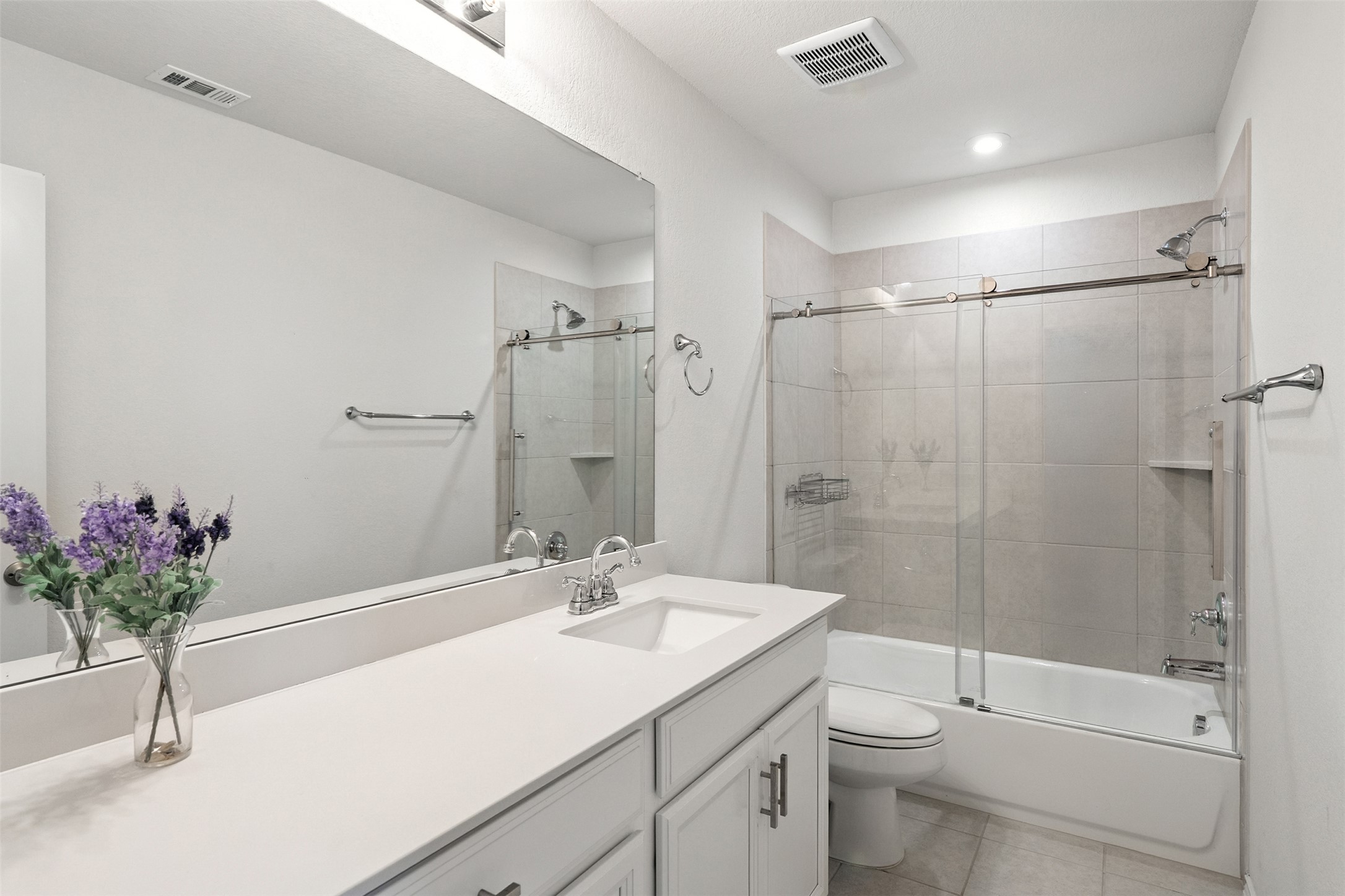 211 Brookside Street Hutto, TX 78634 - Photo 30 of 40 Full bathroom with bath / shower combo with glass door, vanity, light tile patterned floors, and recessed lighting