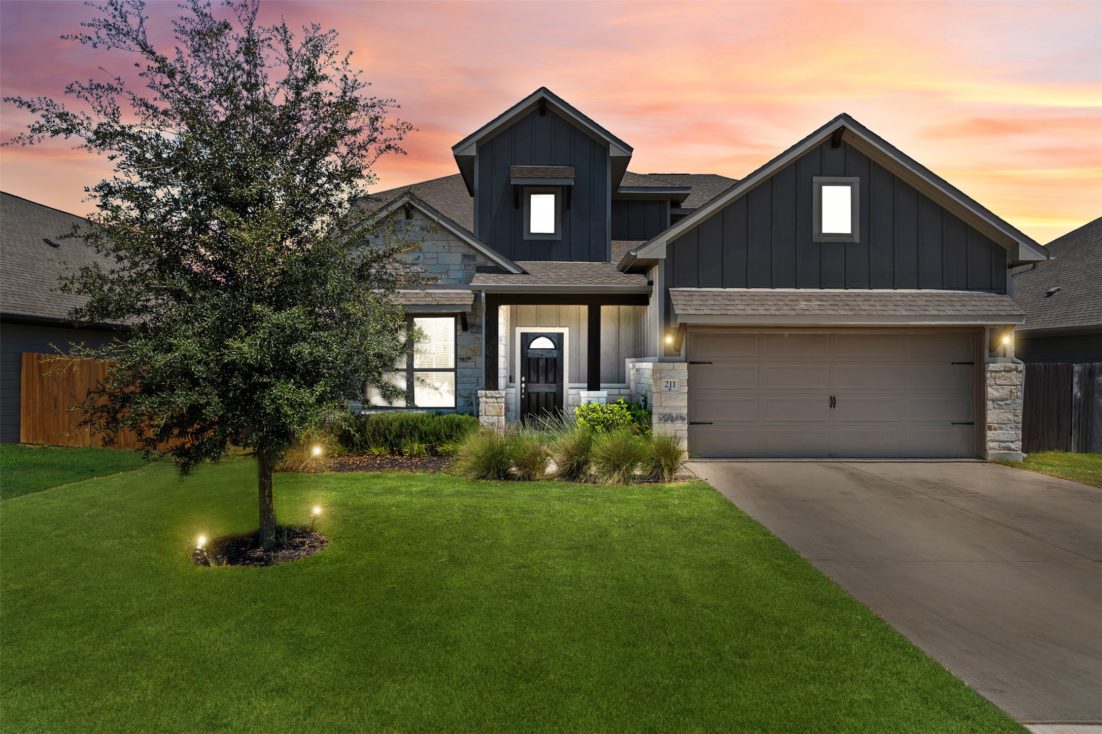 211 Brookside Street Hutto, TX 78634 - Photo 4 of 40 View of front of property with board and batten siding, stone siding, driveway, and a garage