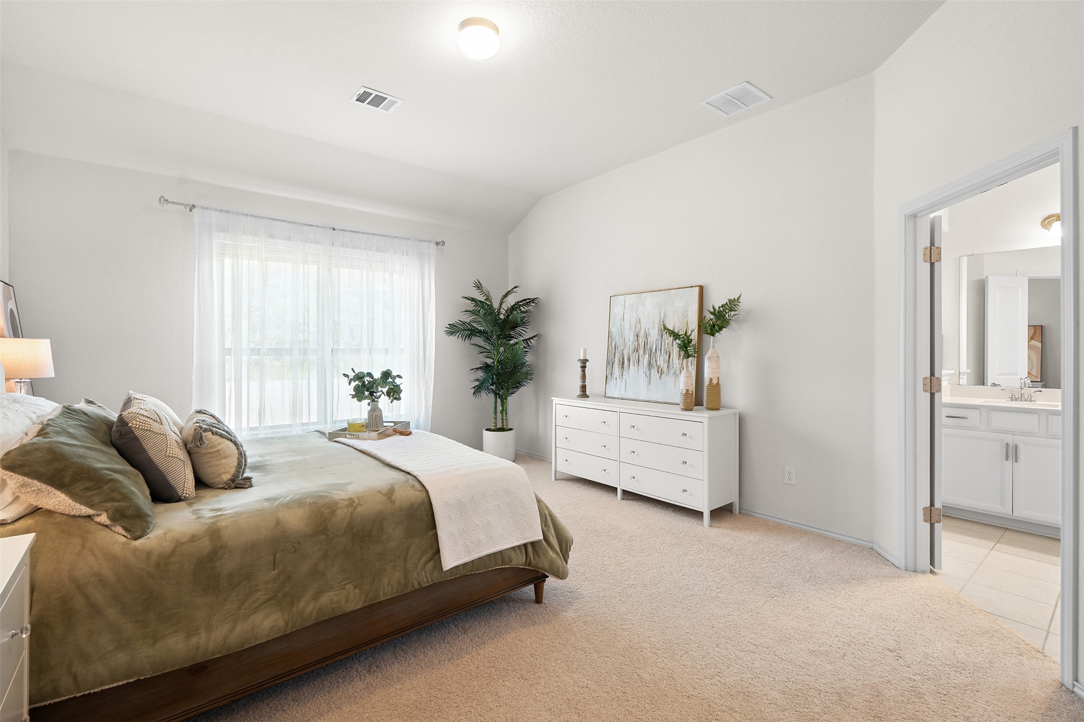 211 Brookside Street Hutto, TX 78634 - Photo 6 of 40 Bedroom with light colored carpet, lofted ceiling, ensuite bath, and light tile patterned flooring